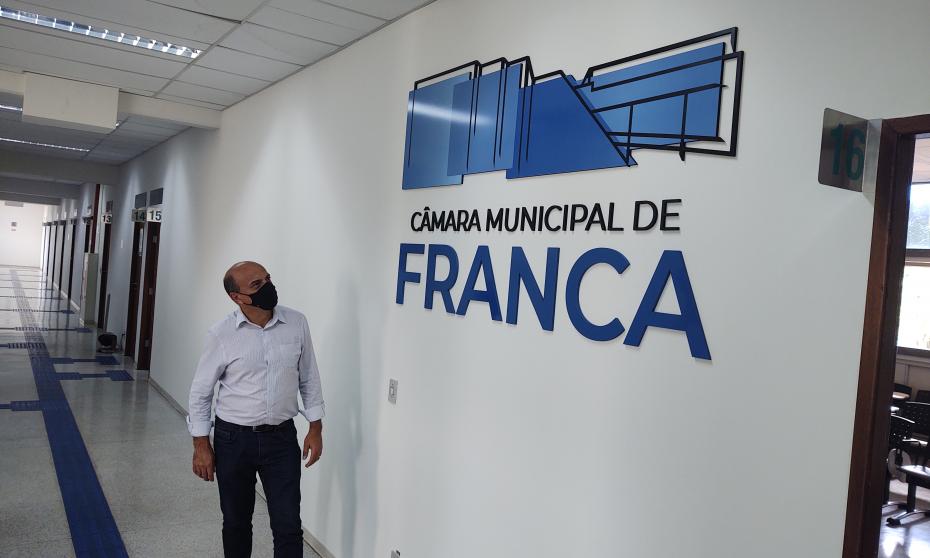 O presidente da Câmara, Claudinei da Rocha, posa ao lado do logotipo oficial da Câmara